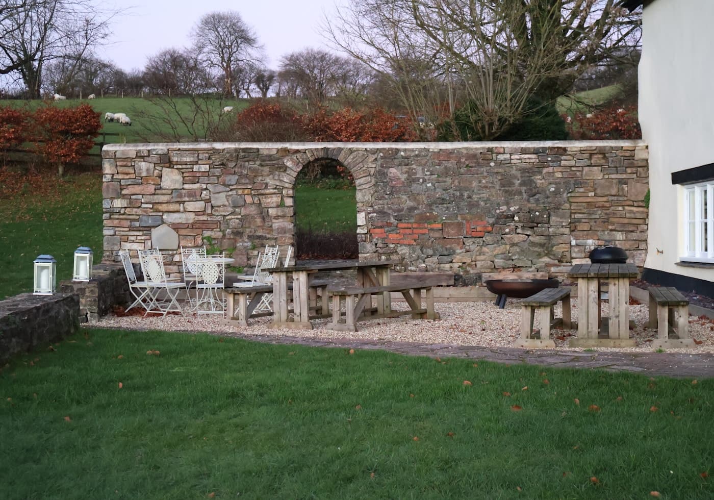An outdoor patio with a stone wall and garden furniture