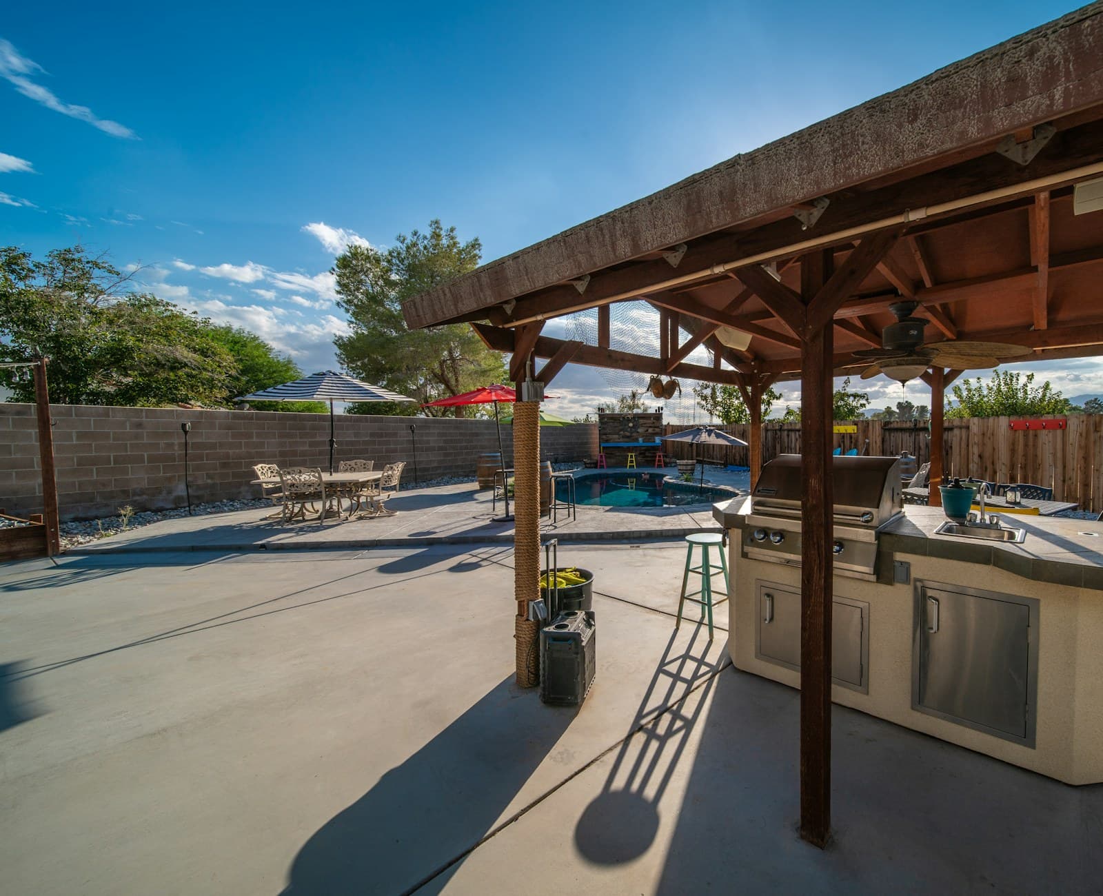 A covered patio fitted with a grill and dining table