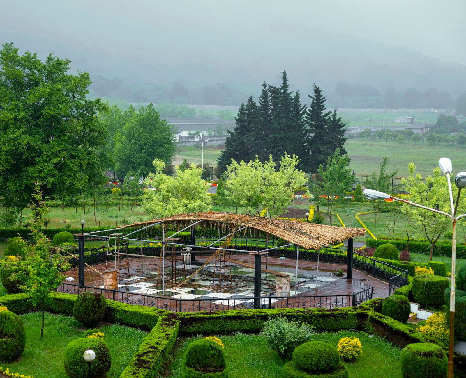 A lush garden of clipped hedging around a covered seating area
