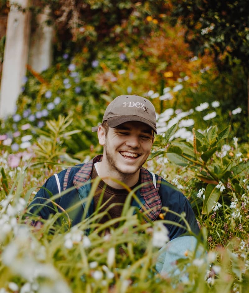 A member of the Verdora crew outdoors in a cap and work shirt